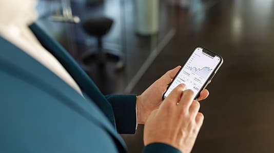 A lady viewing a share price jump up on her phone.