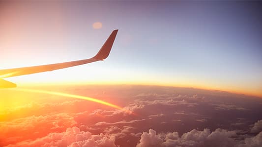 A wide angle shot of a planes wing as it soars in the air.