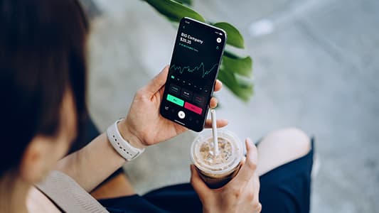 A woman watches the share price of an investment.