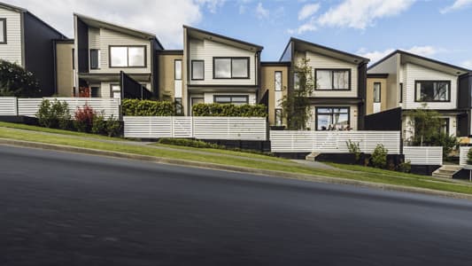 A photo of a residential street on a downward hill.