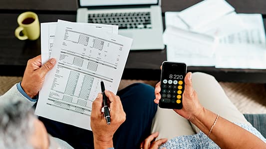 A POV shot of two people working out financial calculations.