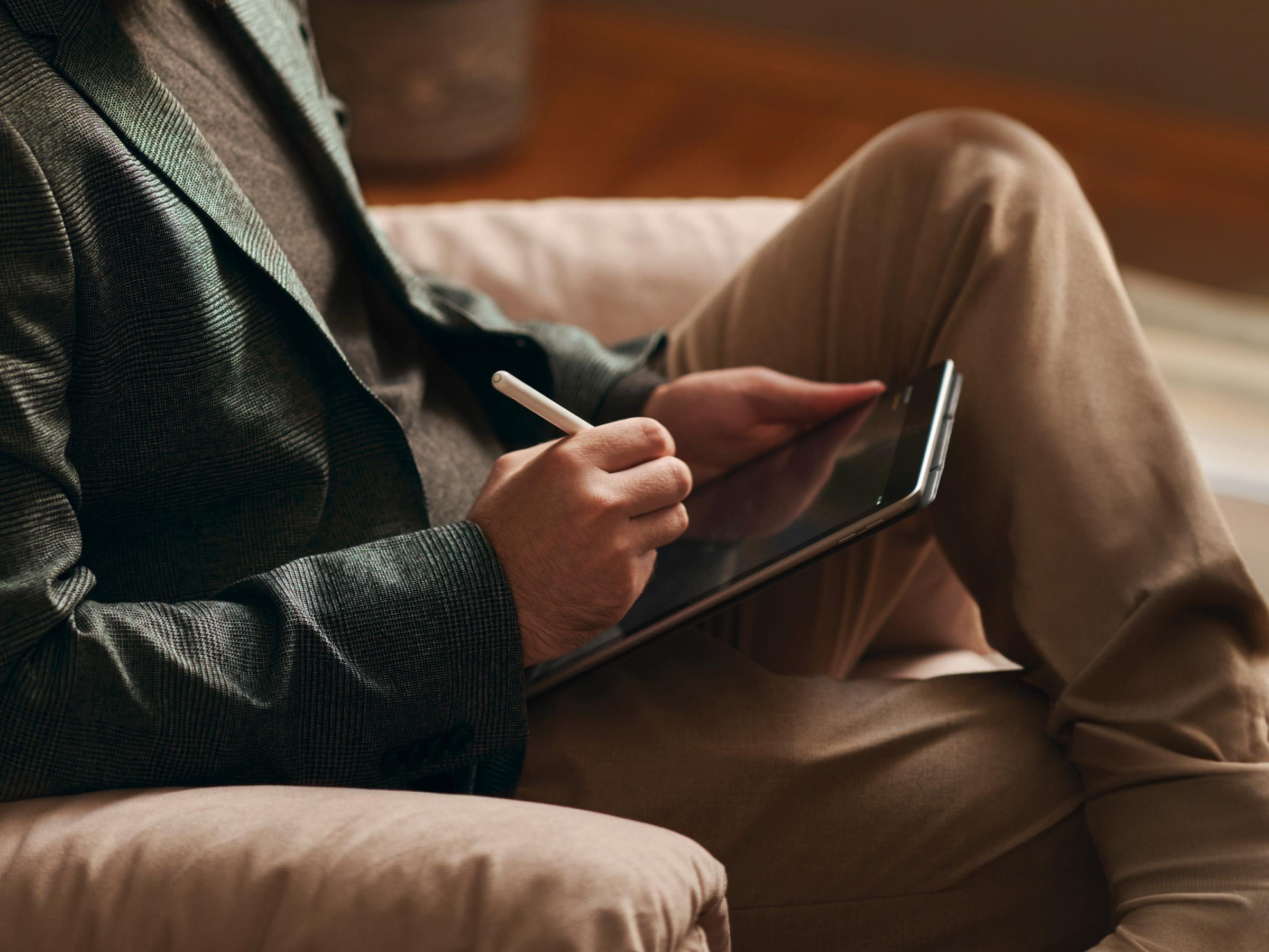 Man sitting on armchair with a tablet device.
